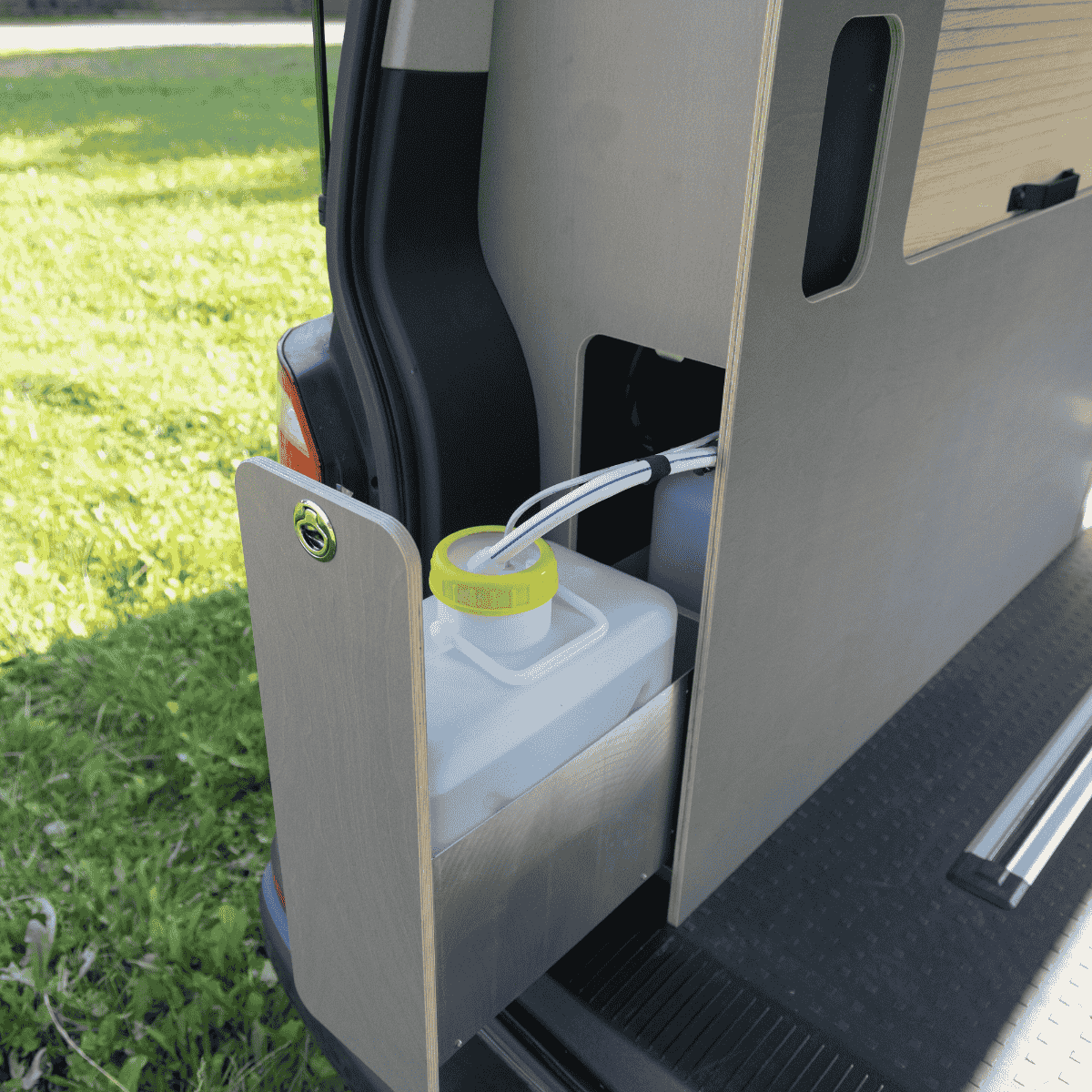 Schranksystem CaliOne im VW T5/T6 California Beach mit rechter Schiebetür, Wasserkanister und Schlauchanschluss sichtbar
