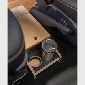 MobyCube Organizer in VW T5-T6.1, zwischen Sitzen platziert, mit Getränkehaltern und Holzoptik für praktischen Stauraum.