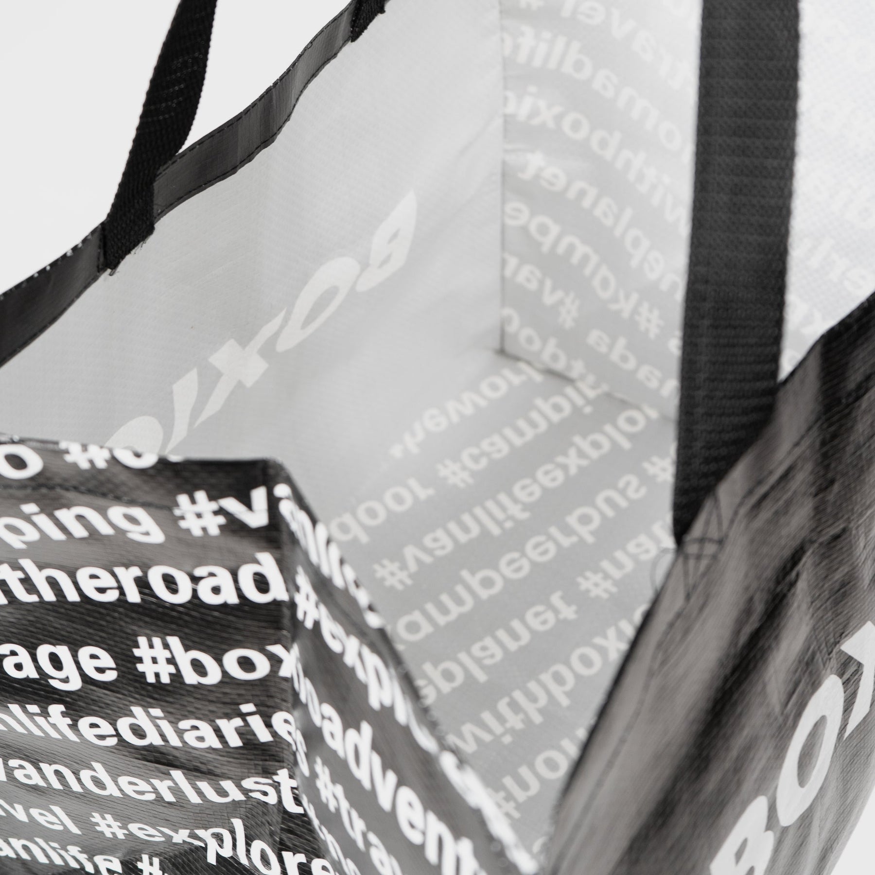 BOXIO BAG Tragetasche innen mit weißen Hashtags und schwarzem Gurtband, Nahaufnahme des robusten Materials und Innenfutter