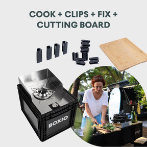 BOXIO KITCHEN PLUS mobile Outdoorküche mit Gasbrenner, Schneidbrett und Clips, Frau bereitet Essen am Campingtisch zu