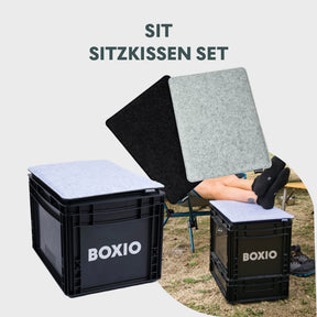 BOXIO SIT Sitzkissen Set für mobiles Badezimmer mit zwei grauen Sitzpolstern auf schwarzen Boxen im Campingbereich